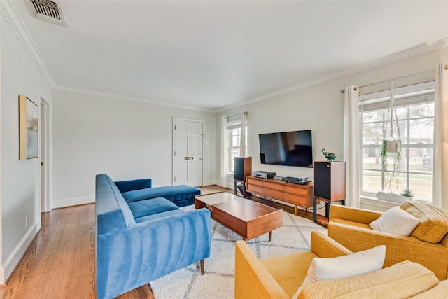 living area with light wood-type flooring, plenty of natural light, ornamental molding, and baseboards