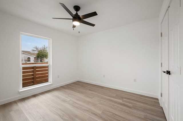 unfurnished bedroom featuring ceiling fan, light wood finished floors, a closet, and baseboards