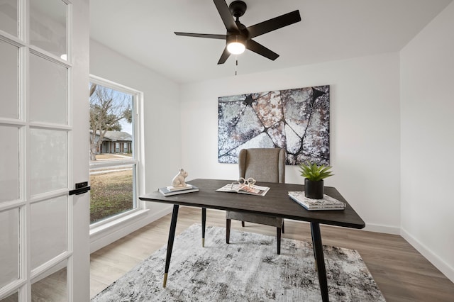 home office featuring a ceiling fan, baseboards, and wood finished floors