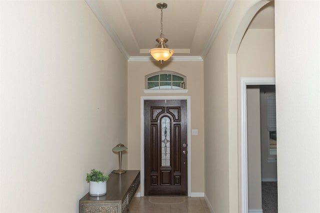 foyer with arched walkways, baseboards, tile patterned flooring, and crown molding