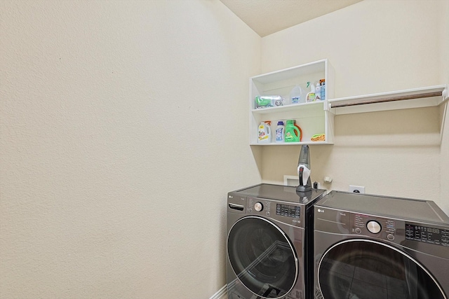 washroom with laundry area, separate washer and dryer, and baseboards