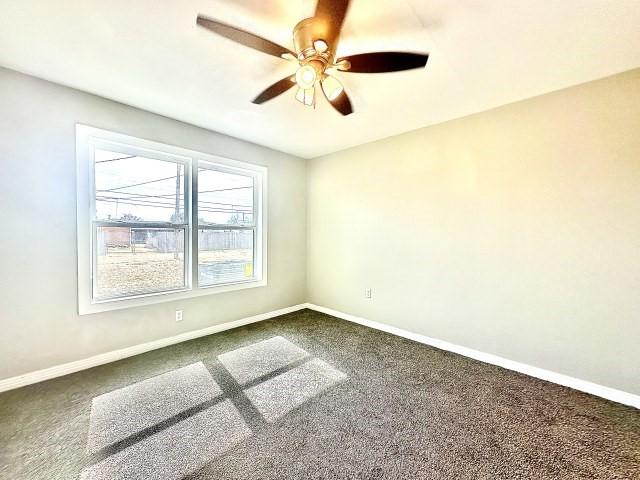 empty room featuring carpet, a ceiling fan, and baseboards