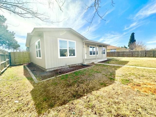 view of side of property featuring a fenced backyard and a yard