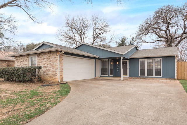 single story home featuring driveway, roof with shingles, an attached garage, fence, and brick siding