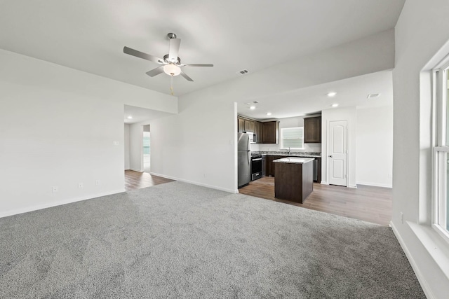 unfurnished living room featuring dark colored carpet, baseboards, and recessed lighting