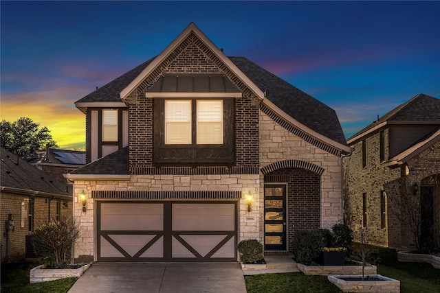 view of front of house featuring brick siding, a shingled roof, a garage, stone siding, and driveway