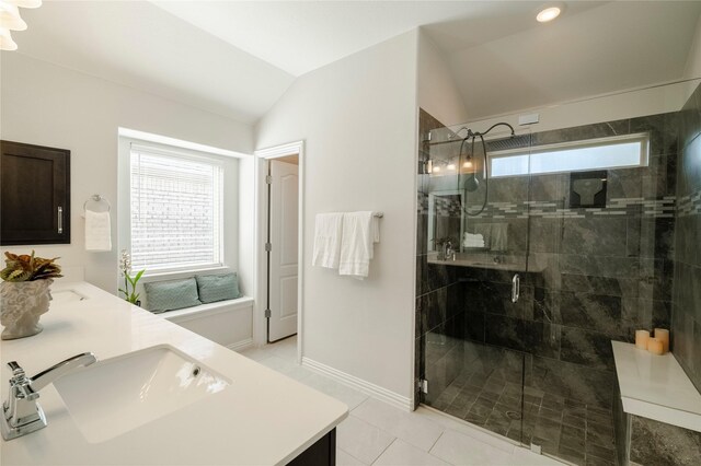 bathroom with a healthy amount of sunlight, a shower stall, a sink, and lofted ceiling