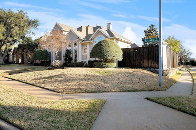 view of front of home with a front yard, fence, and stucco siding