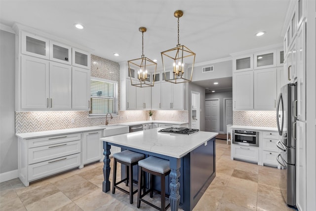 kitchen featuring light countertops, a kitchen island, glass insert cabinets, and pendant lighting