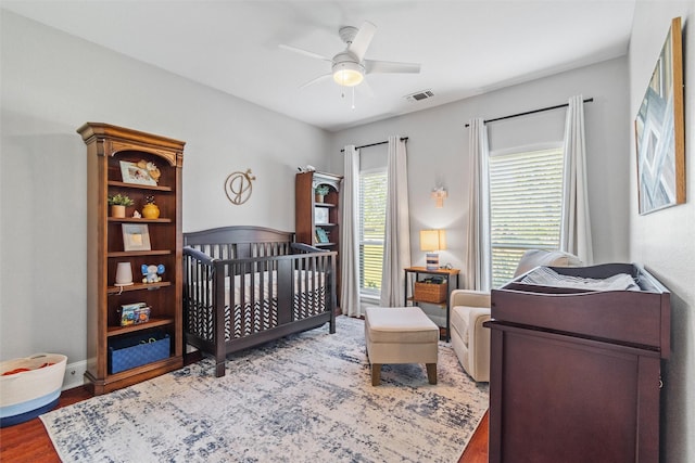 living area featuring light carpet, ceiling fan, visible vents, and baseboards