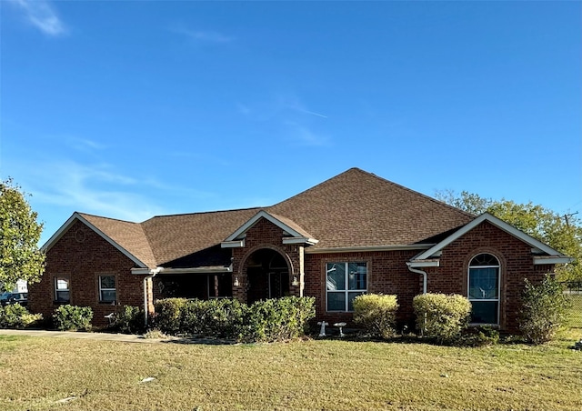 view of front of property featuring a front yard and brick siding