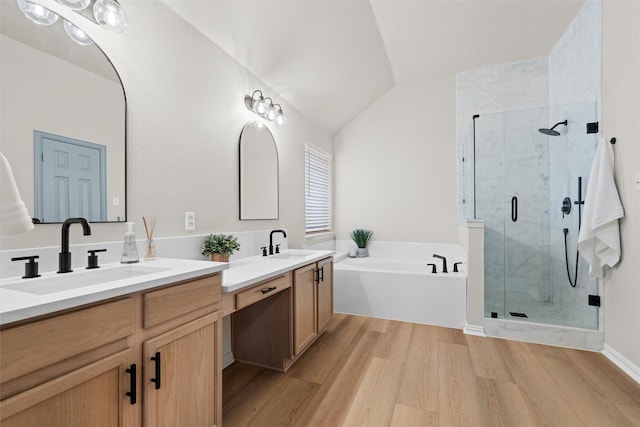 full bath featuring double vanity, a sink, a shower stall, wood finished floors, and a bath