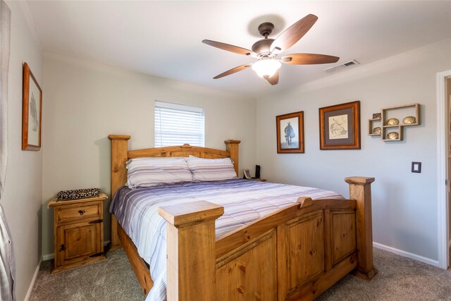 carpeted bedroom featuring baseboards, visible vents, and a ceiling fan