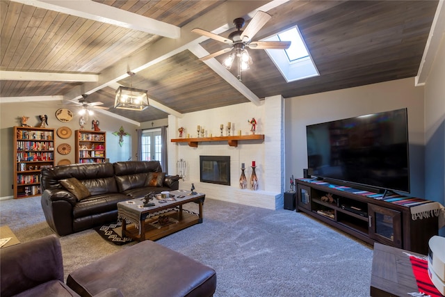 living area with lofted ceiling with skylight, carpet, a fireplace, and ceiling fan