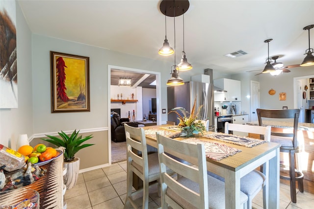 dining area featuring light tile patterned floors, ceiling fan, and visible vents