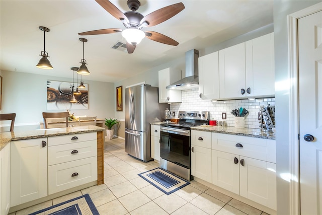 kitchen with stainless steel appliances, light stone counters, wall chimney exhaust hood, and white cabinets