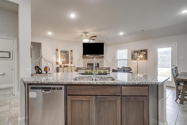 kitchen with ceiling fan, a sink, a fireplace, dishwasher, and visible vents