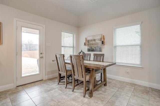 dining area featuring light tile patterned flooring, baseboards, and a healthy amount of sunlight