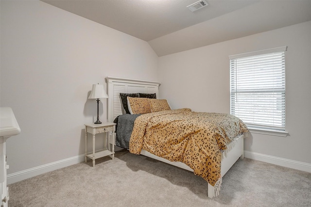 carpeted bedroom featuring baseboards, visible vents, and lofted ceiling