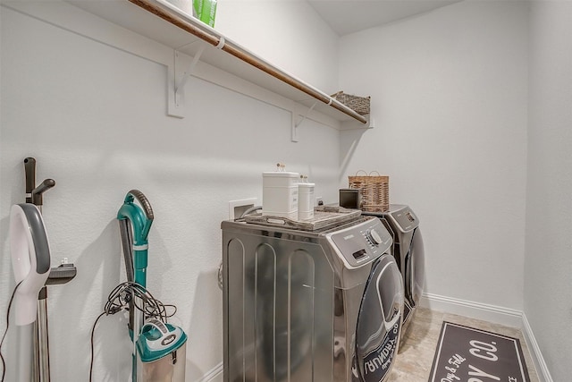laundry area with baseboards, laundry area, and washing machine and clothes dryer