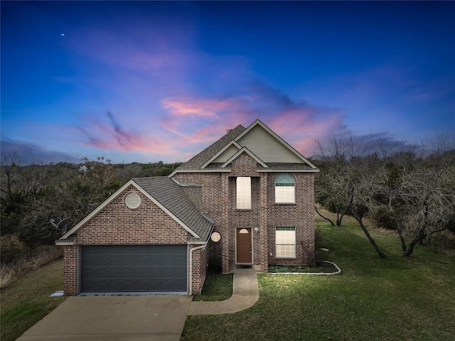 traditional-style home with a garage, concrete driveway, brick siding, and a front lawn