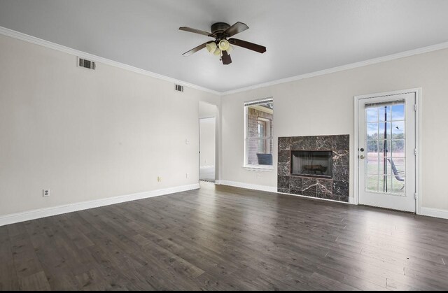 unfurnished living room featuring crown molding, dark wood finished floors, visible vents, a premium fireplace, and baseboards