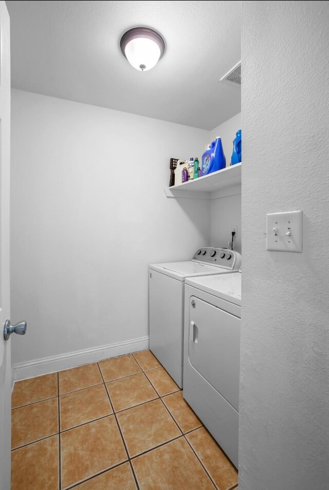 laundry room featuring laundry area, light tile patterned floors, baseboards, visible vents, and independent washer and dryer