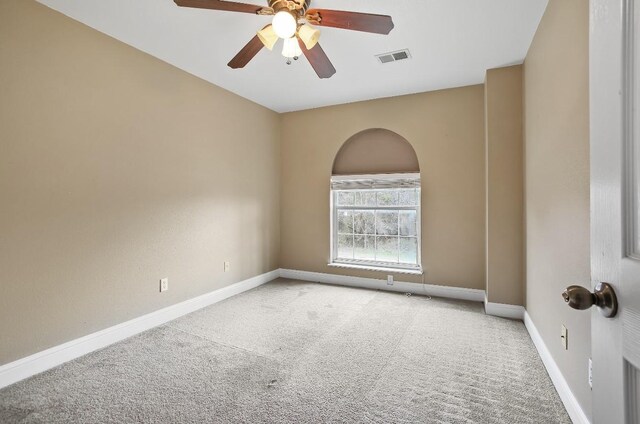 carpeted empty room featuring visible vents, ceiling fan, and baseboards