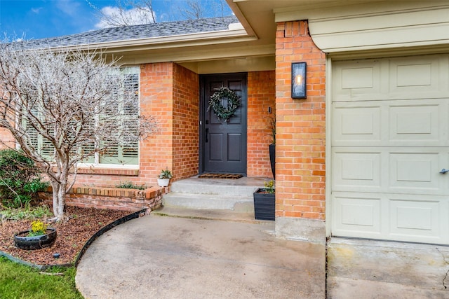 doorway to property with brick siding and roof with shingles