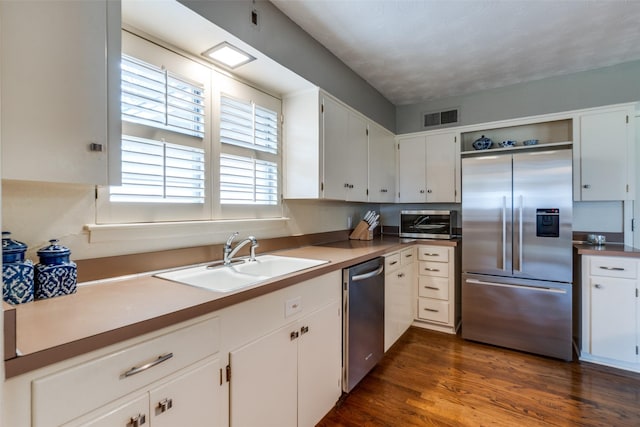 kitchen with open shelves, visible vents, appliances with stainless steel finishes, white cabinetry, and a sink