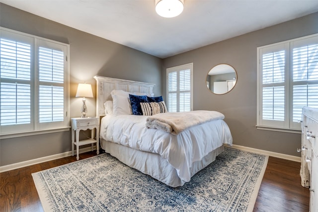 bedroom with baseboards and dark wood-type flooring