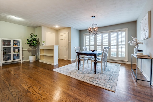 dining area featuring a notable chandelier, baseboards, and dark wood-type flooring