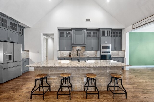 kitchen with stainless steel appliances, visible vents, glass insert cabinets, and gray cabinetry