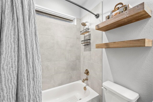 bathroom with toilet, shower / bathtub combination with curtain, and a textured wall