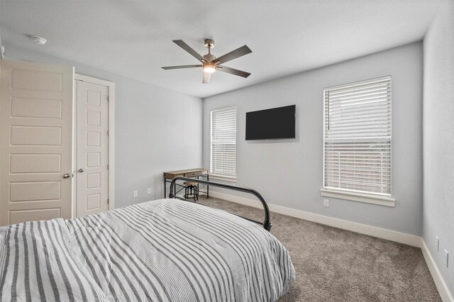 carpeted bedroom with ceiling fan and baseboards