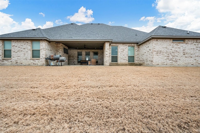 back of property featuring a patio area, a shingled roof, ceiling fan, and brick siding