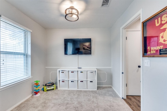 recreation room featuring light carpet and visible vents