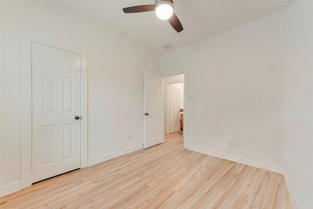 unfurnished bedroom with baseboards, visible vents, a ceiling fan, and light wood-style floors