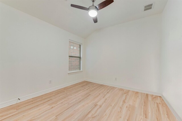 empty room featuring a ceiling fan, baseboards, vaulted ceiling, visible vents, and light wood-style floors