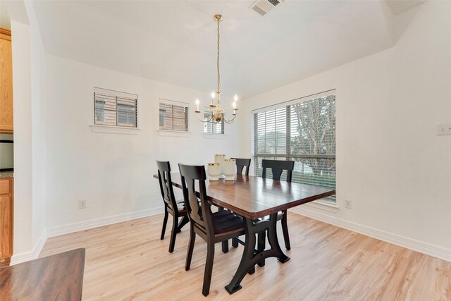 dining space with baseboards, an inviting chandelier, visible vents, and light wood-style floors