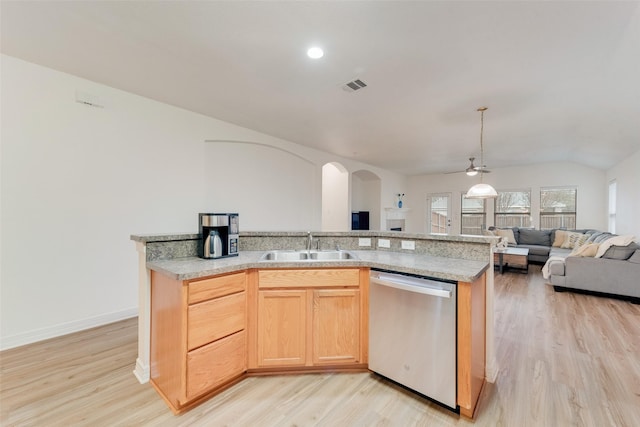 kitchen with light wood finished floors, stainless steel dishwasher, light brown cabinetry, open floor plan, and a sink