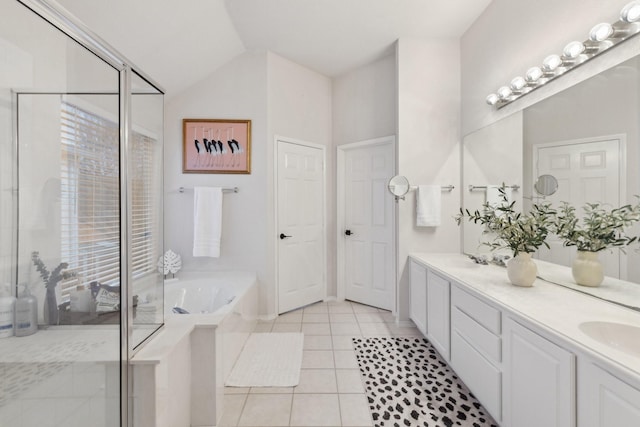 bathroom featuring tile patterned flooring, a sink, a bath, double vanity, and a stall shower