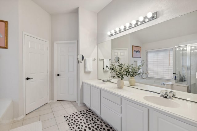 full bath featuring a bath, tile patterned flooring, double vanity, and a sink