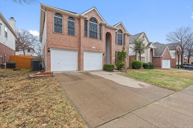 traditional home with an attached garage, brick siding, fence, driveway, and a front lawn