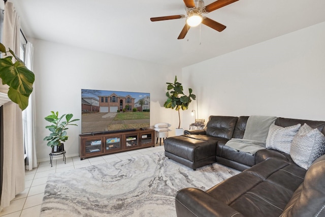 living area featuring light tile patterned floors, ceiling fan, and baseboards