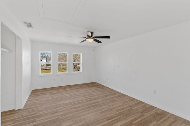 unfurnished room featuring ceiling fan, baseboards, visible vents, and light wood-style floors