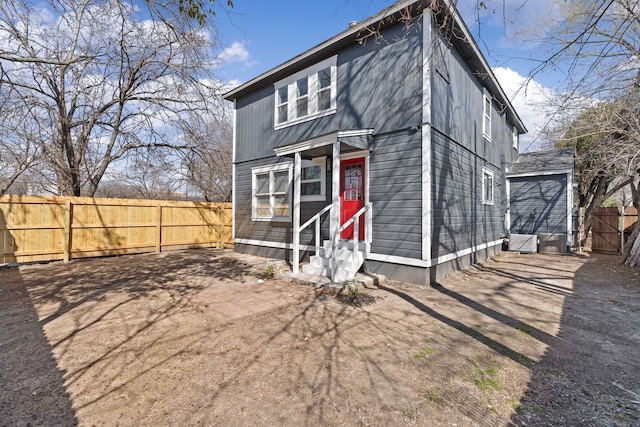 back of property with entry steps and fence