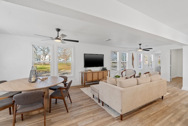 living area with light wood finished floors, visible vents, and baseboards