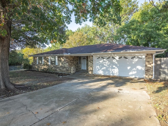 ranch-style home with a garage, brick siding, and driveway