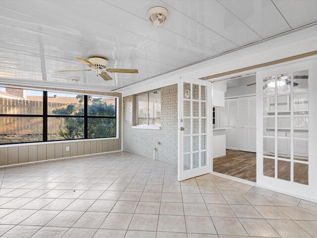 unfurnished sunroom featuring french doors and ceiling fan